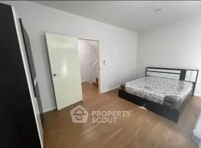 Spacious bedroom with modern bed and wooden flooring, ideal for comfort and relaxation.