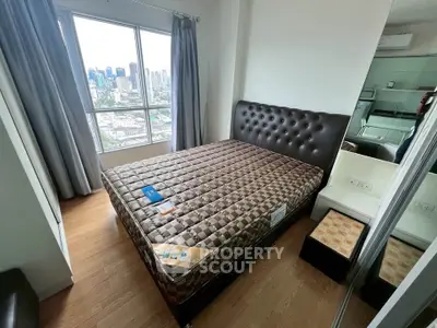 Modern bedroom with city view, featuring a stylish bed and large window for natural light.