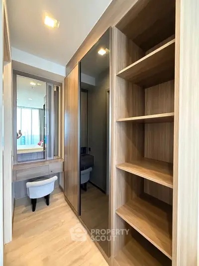 Spacious walk-in closet with modern wooden shelving and mirrored doors