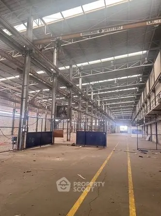 Spacious industrial warehouse with high ceilings and ample natural light.