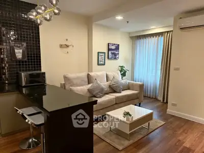 Modern living room with cozy sofa, stylish decor, and open kitchen layout.