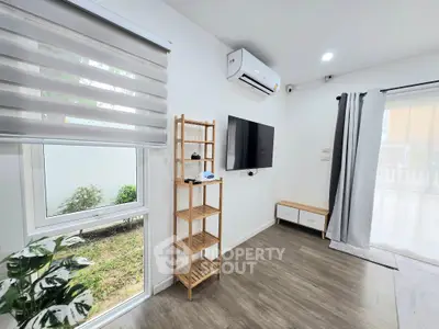 Modern living room with air conditioning, TV, and stylish decor in a bright, airy space.