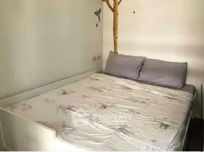 Cozy bedroom with unique tree wall decal and comfortable bedding, perfect for relaxation.