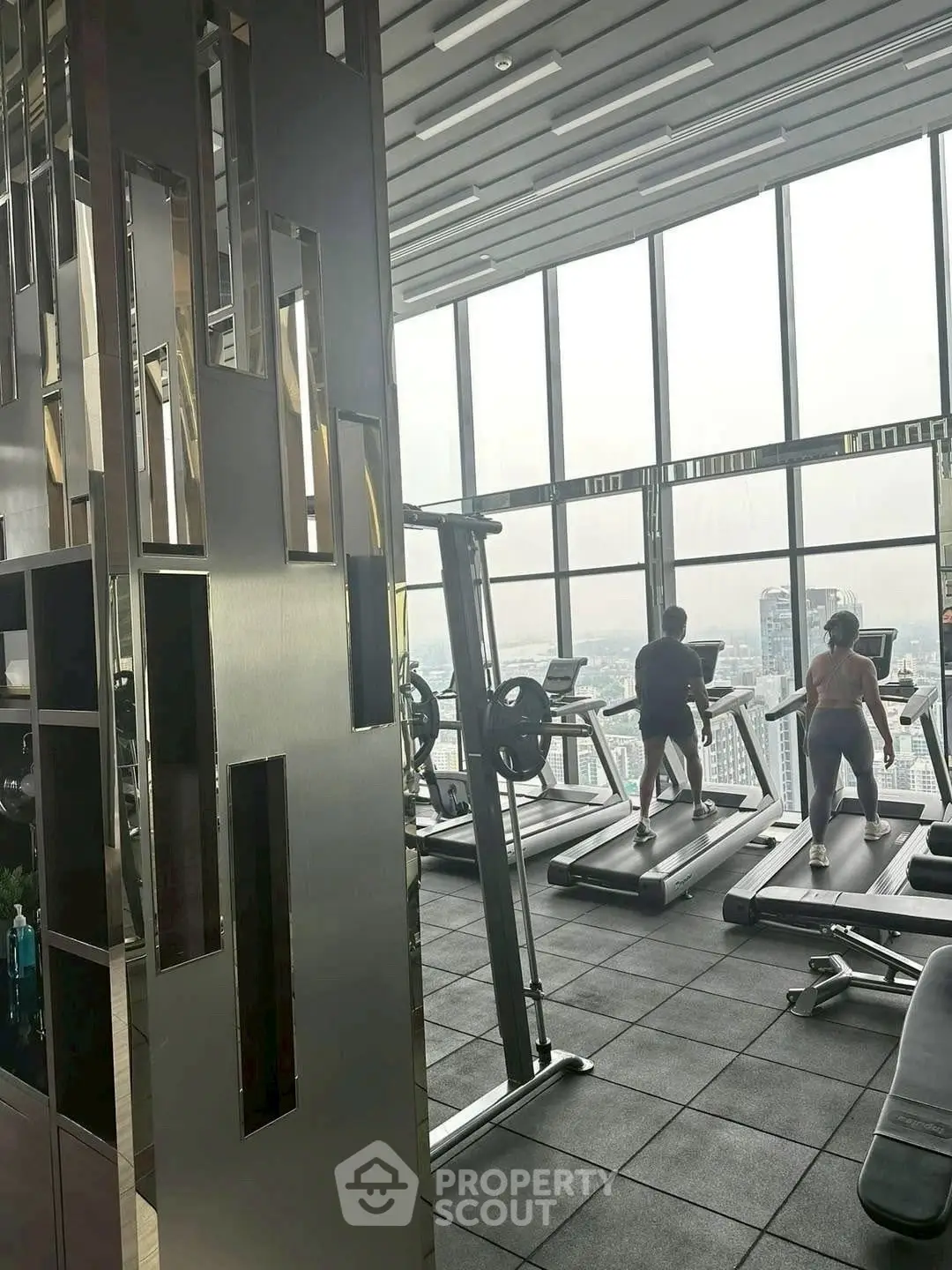 Modern high-rise gym with panoramic city views and state-of-the-art equipment.
