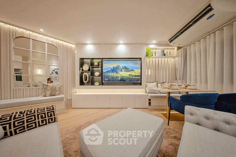 Luxurious modern living room with elegant decor and large TV, perfect for relaxation and entertainment.