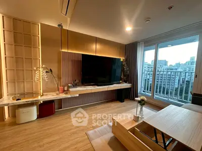 Modern living room with large TV, wooden flooring, and city view balcony.