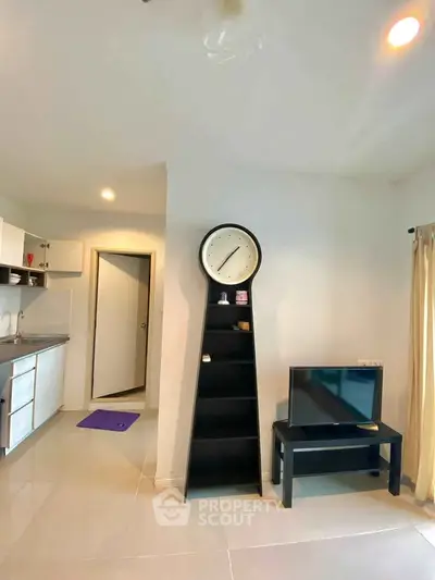 Modern living room with sleek black shelving and compact kitchen area