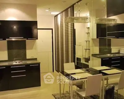 Modern kitchen with sleek black cabinets and dining area in open layout apartment.