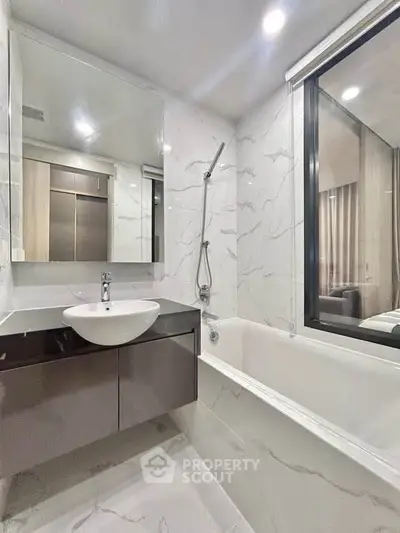 Modern bathroom with sleek design, featuring a bathtub and stylish fixtures in a contemporary apartment.