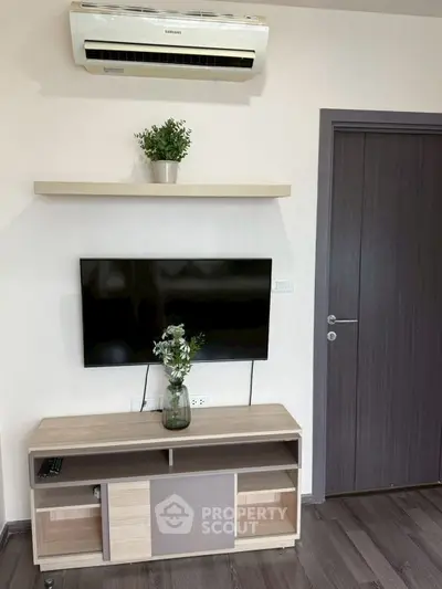 Modern living room with wall-mounted TV and air conditioning unit.