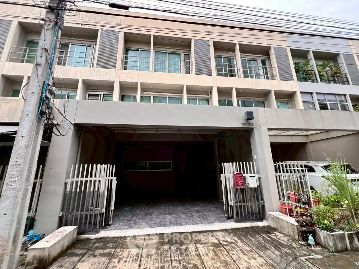 Modern townhouse exterior with gated entrance and large windows.