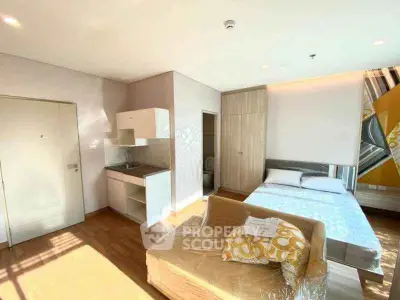 Bright studio apartment with modern furnishings and compact kitchen area, ideal for urban living.