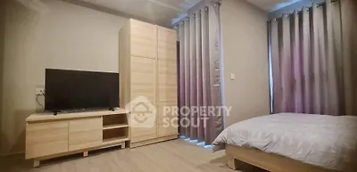 Cozy bedroom with modern wooden furniture and large windows with curtains.