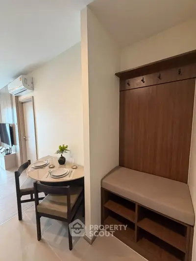 Modern dining area with stylish seating and wall-mounted air conditioning in a cozy apartment.