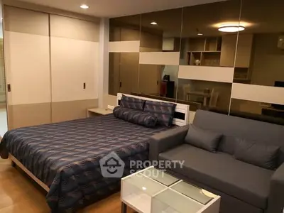 Modern bedroom with stylish decor and cozy seating area in a contemporary apartment.