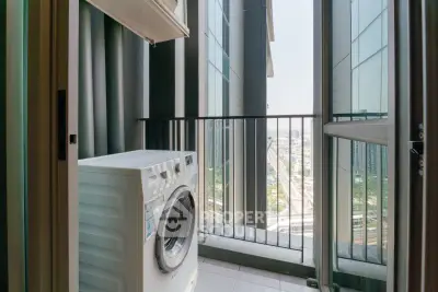Modern apartment balcony with washing machine and city view