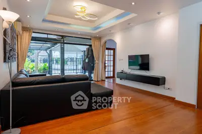 Spacious living room with modern decor and large windows opening to a garden view.