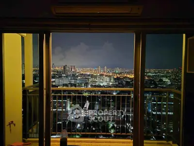 Stunning cityscape view from high-rise balcony at night, showcasing vibrant urban lights.