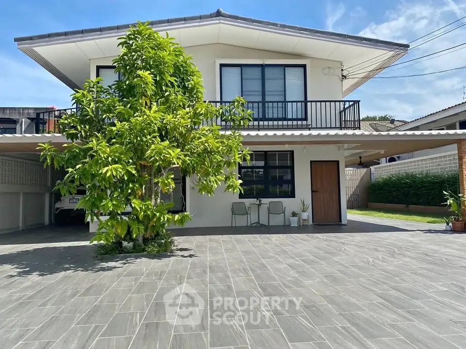 Modern two-story house with spacious driveway and lush greenery