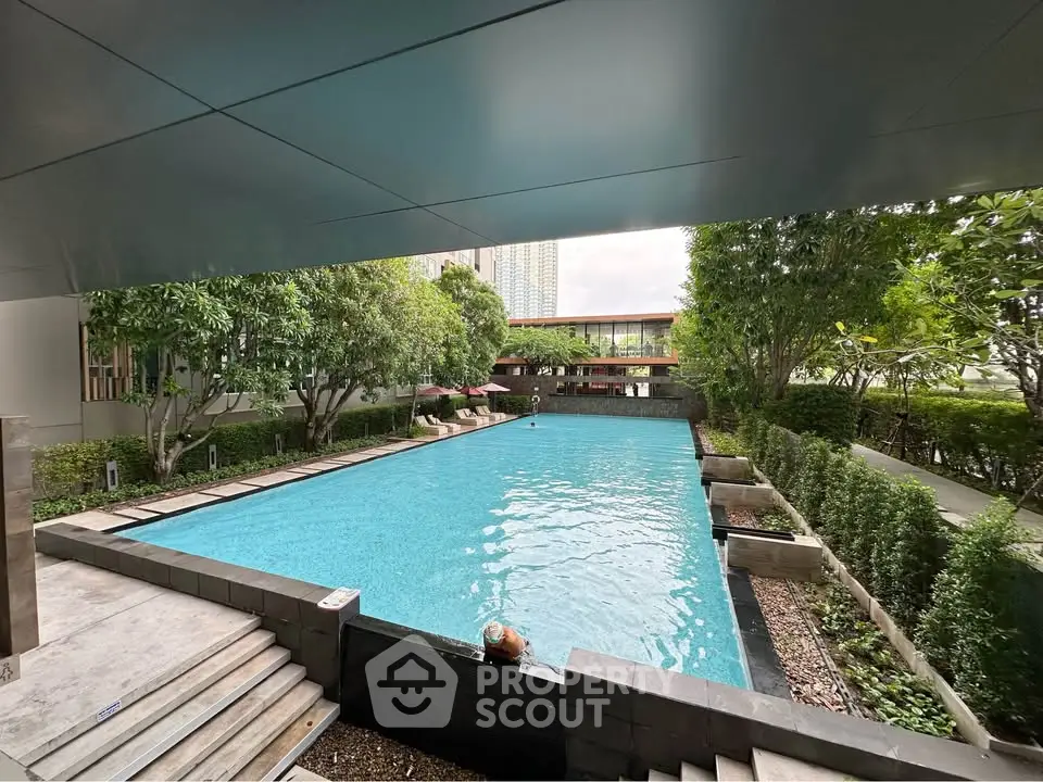 Luxurious outdoor pool area with lush greenery and modern architecture, perfect for relaxation and leisure.