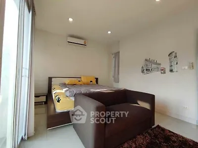 Cozy bedroom with modern decor and natural light, featuring a comfortable bed and stylish seating area.