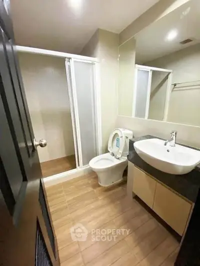 Modern bathroom with sleek fixtures and spacious shower in a contemporary apartment.