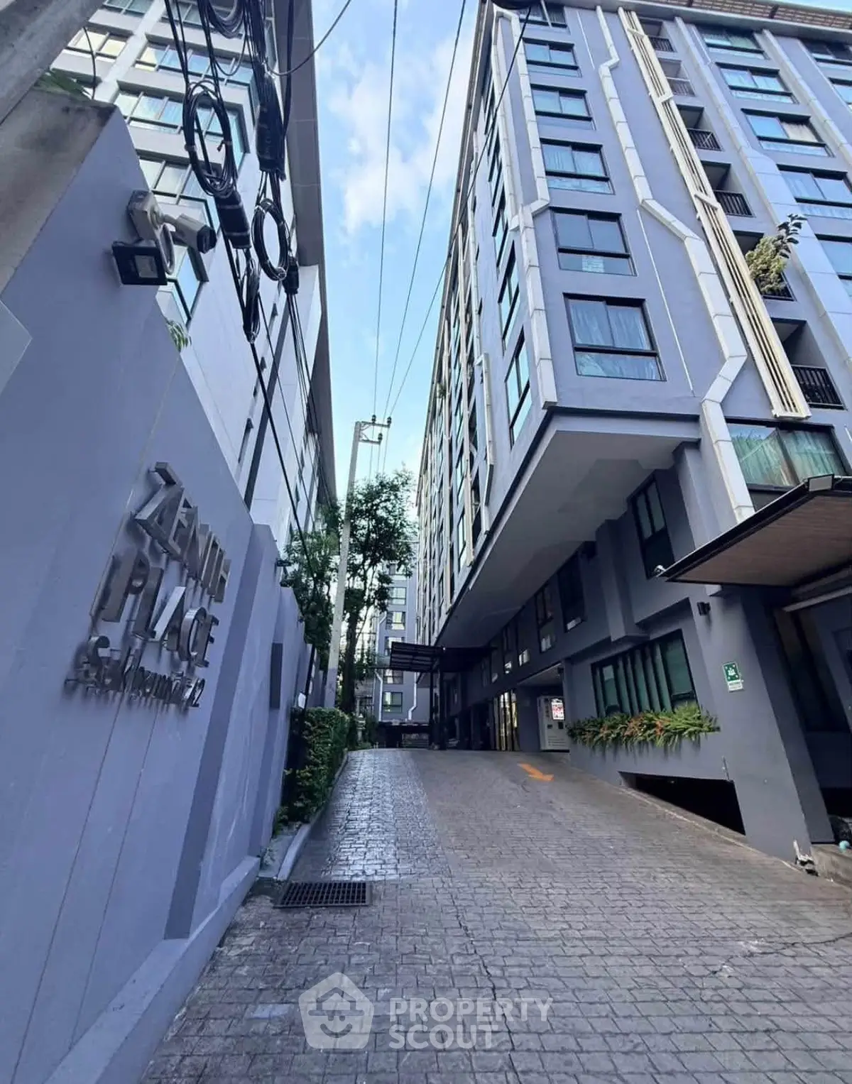 Modern high-rise building exterior with sleek design and spacious driveway entrance.