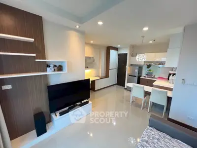 Modern open-plan living room with sleek kitchen and dining area, featuring contemporary furniture and stylish decor.