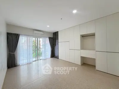 Spacious modern living room with large windows and built-in storage