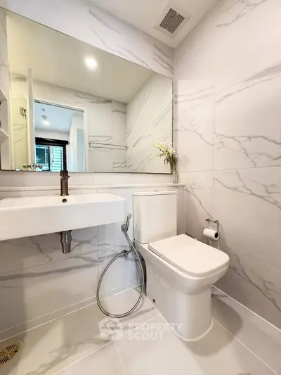 Modern bathroom with sleek white fixtures and marble tile design