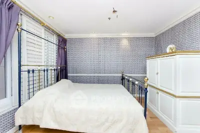 Elegant bedroom with stylish wallpaper and classic metal bed frame