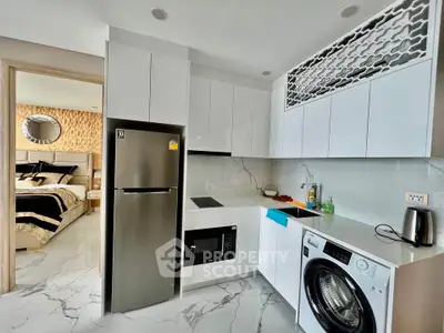 Modern kitchen with sleek appliances and view into stylish bedroom