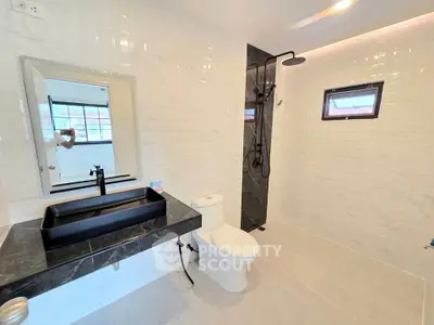 Modern bathroom with sleek black fixtures and spacious shower area
