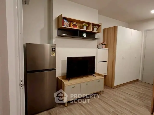 Modern living room with sleek furniture and stainless steel fridge