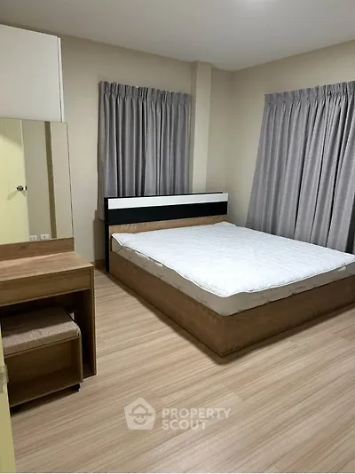 Modern bedroom with sleek wooden furniture and neutral curtains