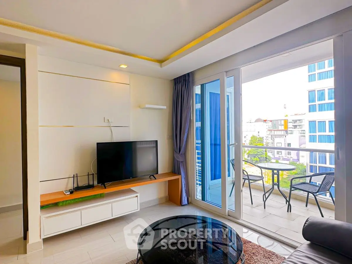 Modern living room with large windows and balcony view, featuring sleek furniture and contemporary design.
