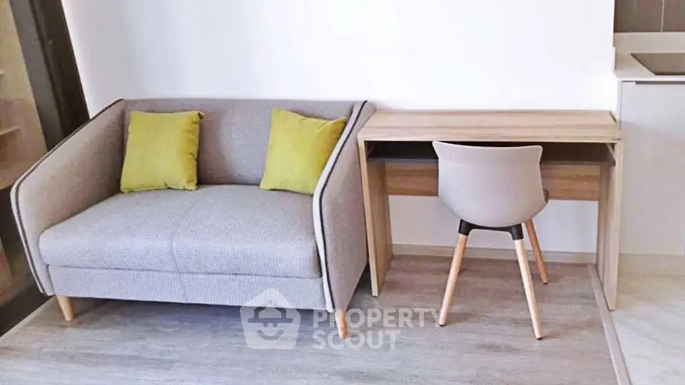 Modern living room with stylish sofa and compact study desk, perfect for urban living.