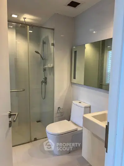 Modern bathroom with glass shower and sleek fixtures in a contemporary apartment.