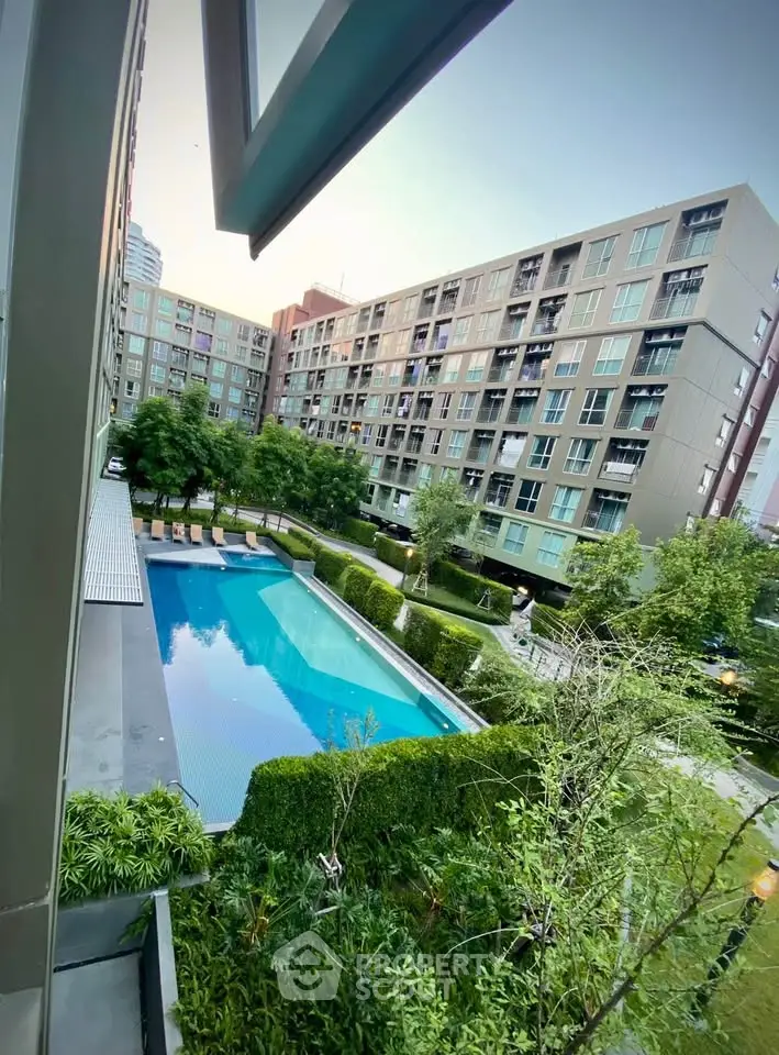 Modern apartment complex with a stunning outdoor pool and lush greenery, perfect for urban living.