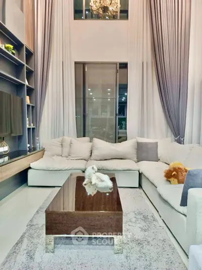 Luxurious living room with high ceilings, elegant chandelier, and plush sectional sofa for ultimate comfort.