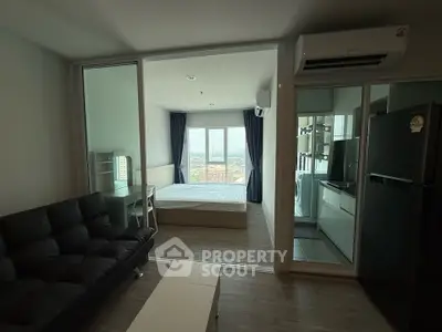 Modern studio apartment with open layout, featuring a cozy living area, sleek kitchen, and stunning city view.
