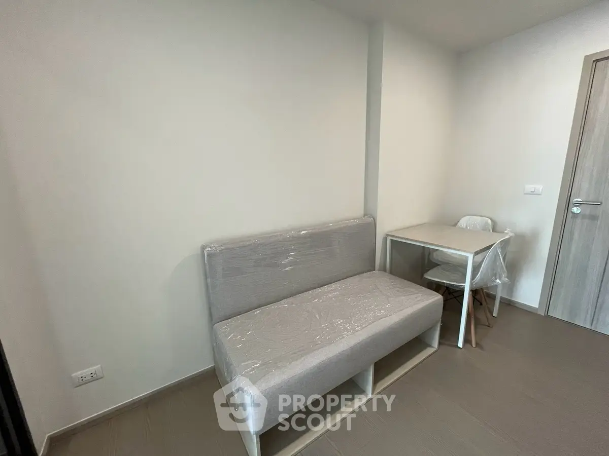 Modern minimalist room with compact sofa and dining table, perfect for small living spaces.