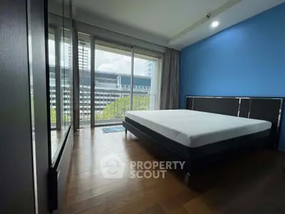 Spacious bedroom with modern design and large windows offering city views.