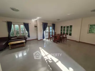 Spacious living room with elegant dining area and ample natural light
