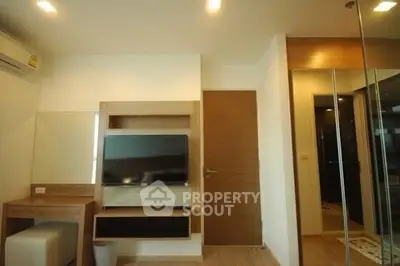 Modern living room with sleek TV setup and stylish wooden accents