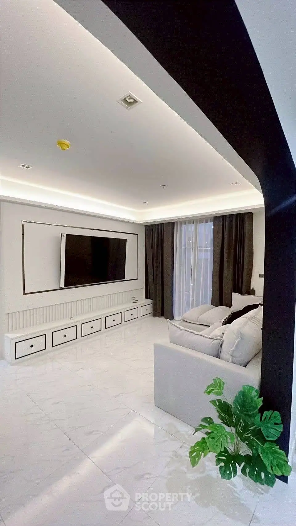 Modern living room with sleek design, large TV, and elegant lighting.