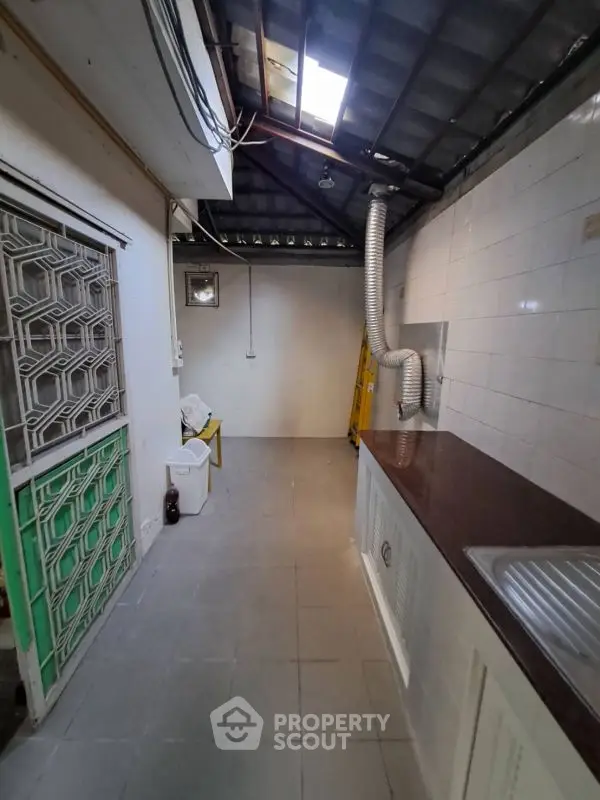 Spacious kitchen with modern countertop and tiled flooring, featuring a unique ceiling design.