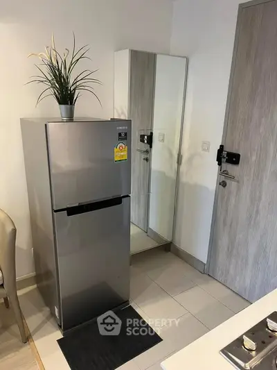 Modern kitchen corner with stainless steel fridge and mirror cabinet