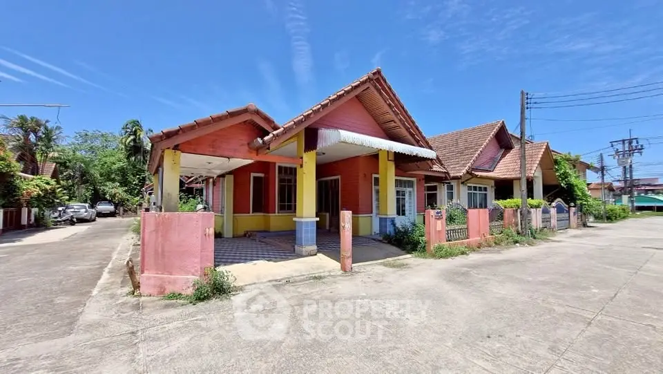 Charming suburban house with tiled roof and spacious driveway under clear blue sky.