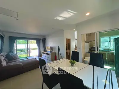Spacious open-plan living and dining area with modern kitchen and garden view.